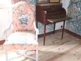 a chair and a desk in a room with a wallpapered wall