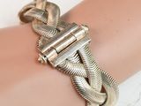 silver metal bracelet with a snake clasp on a woman ' s arm