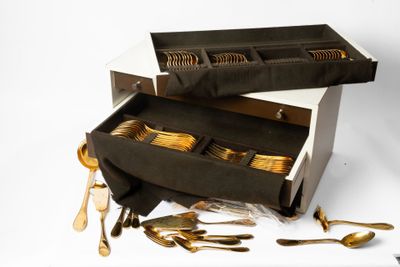 une boîte contenant tout un tas de cuillères en or et d'autres cuillères
