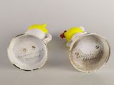 pair of white ceramic salt and pepper shakers with yellow and red handles