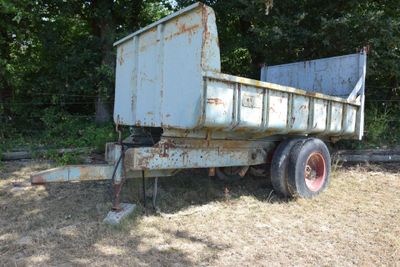 a rusted out dump truck sitting in a field