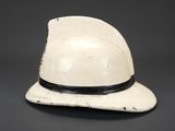 an old white hat with a black band on a black background