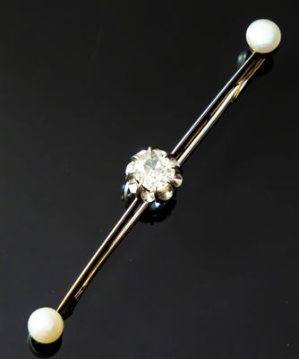 a close up of a single pearl and diamond barbell