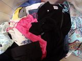 a pile of clothes in a laundry basket on the floor