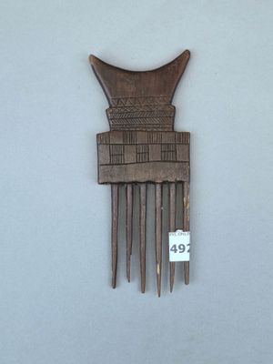 un peigne en bois sur lequel a été sculpté un motif