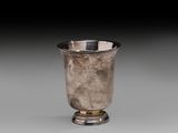 an antique silver cup on a pedestal with a black background