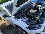 a white car with its hood open and the engine in the trunk