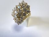 gros plan d'une bague en or avec des diamants sur une surface blanche