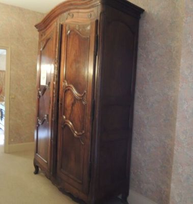 une grande armoire en bois dans le coin d'une pièce