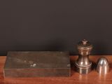 une paire de salière et poivrière anciennes en argent posée sur une table en bois