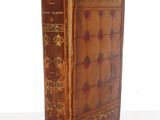 an old book sitting on top of a white table next to a white wall