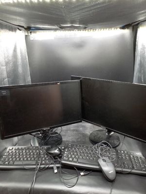 deux écrans d'ordinateur et un clavier posés sur le bureau