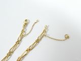 a close up of a pair of gold plated chains on a white surface