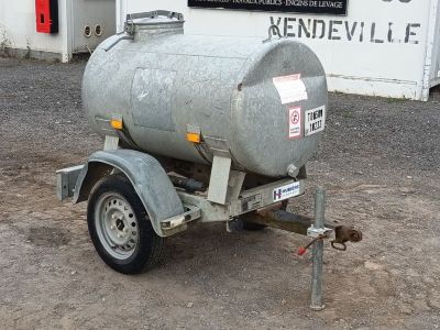 a trailer with a tank attached to it in front of a building