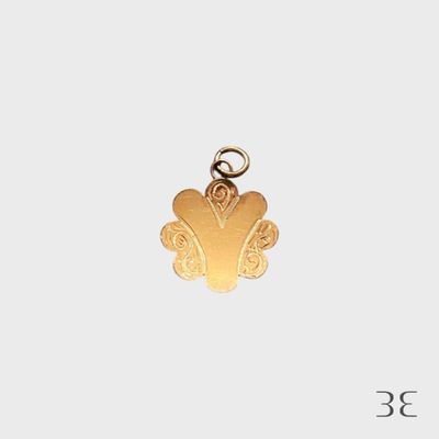 un gros plan d'un pendentif en or sur fond blanc