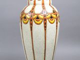 un vase blanc orné de motifs orange et jaunes
