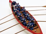 plusieurs personnes dans une barque à rames sur une surface blanche