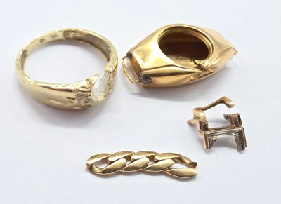 une bague en or et deux autres bagues en or posées sur une surface blanche