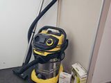 a yellow vacuum and a box of boxes on the floor