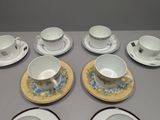 nine cups and saucers sitting on a table