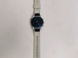 the watch is sitting on a white surface next to a white wall