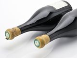two bottles of wine sitting next to each other on a table