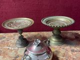two silver vases sitting on a table with a red background