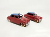 two toy cars that are sitting next to each other on a white surface