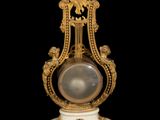 a clock that is sitting on a stand on a black background