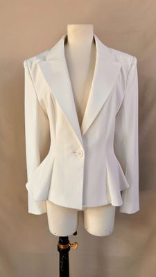 white blazer jacket on a mannequin stand against a beige background