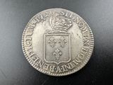 une pièce d'argent surmontée d'une couronne