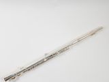 a silver flute on a white surface with a white background