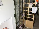 a room with a glass display case and a plant on the wall