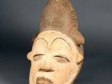 an image of a wooden mask with a hat on it