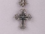 silver cross pendant on black cord necklace on a mannequin mannequin mannequin mannequin mannequin mannequin mannequin manne