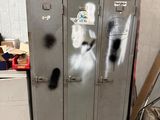 a metal locker with graffiti on it in a room