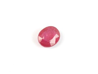 a close up of a pink ruby stone on a white surface