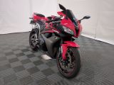 une moto rouge et noire garée sur un sol à damier noir et blanc