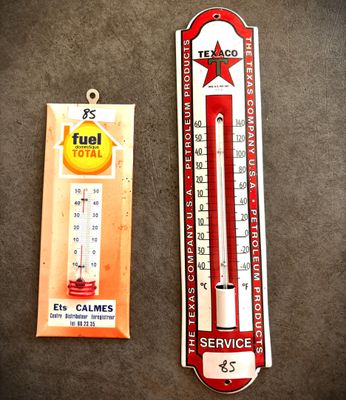 un thermomètre rouge et blanc à côté d'un thermomètre orange et blanc