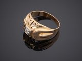 a close up of a gold ring with a diamond on a black surface
