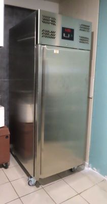 a stainless steel refrigerator in the corner of a room