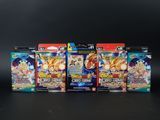 cinq cartes Dragon Ball sont alignées sur une surface noire