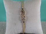 un gros plan sur un coussin sur lequel repose un bracelet en or