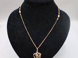 un collier en or avec un pendentif en forme de cœur sur un mannequin noir