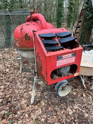 a red machine that is sitting in the leaves