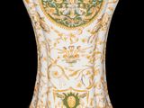 a white vase with a green and gold decoration on it