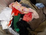 a pile of clothes in a basket on the floor