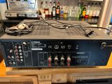 an amplifier sitting on top of a wooden table next to bottles of alcohol