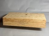 une vieille boîte en bois sur laquelle est collée une étiquette de vin, posée sur une table