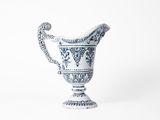 blue and white porcelain pitcher with a handle on a white background
